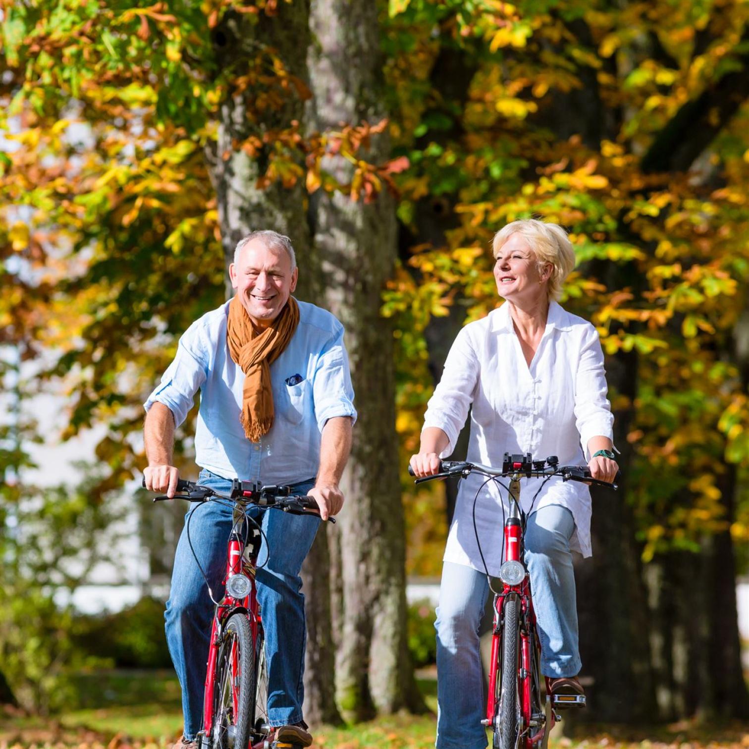 Fietsend ouder echtpaar in de natuur en bij mooi weer natuurlijk