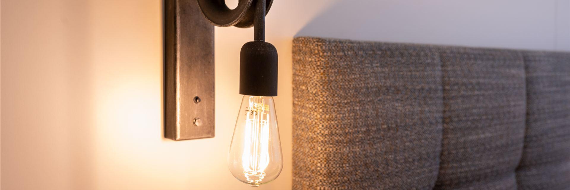 Brandende wandlamp in een Comfortkamer.