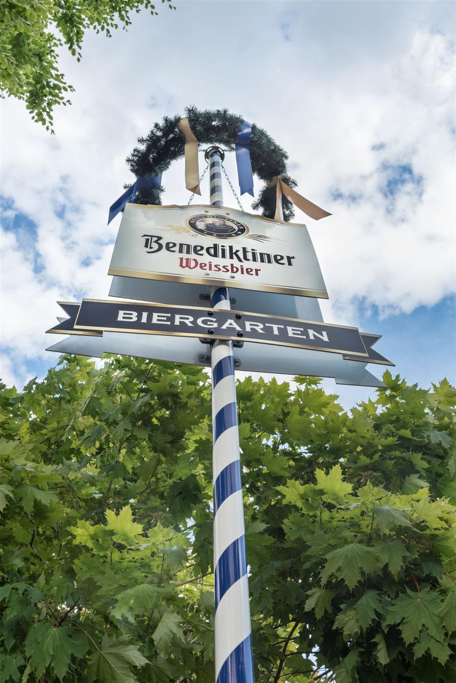 Foto toont een bayerse meiboom met bovenin een krans en daaronder 