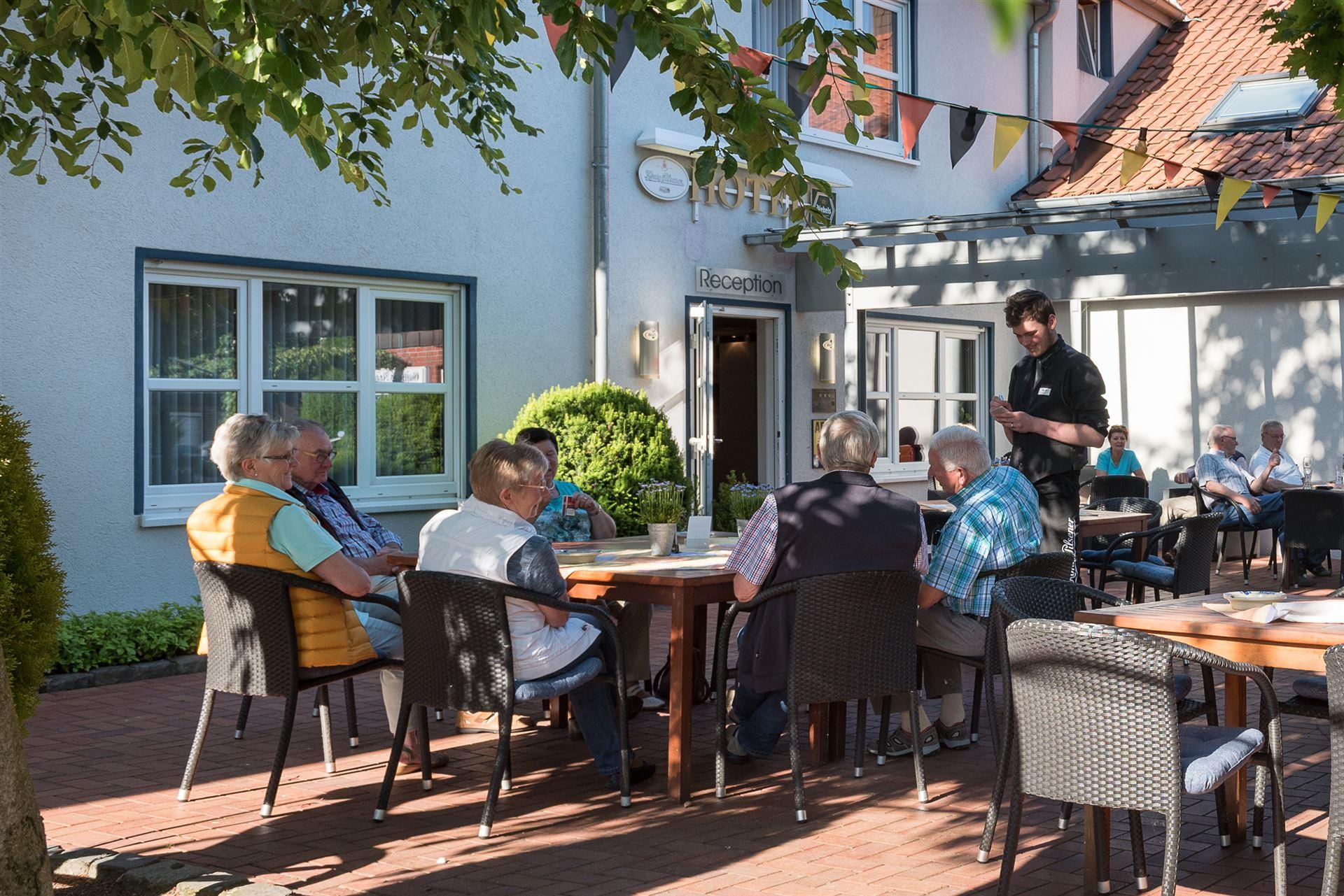 Tafel met gasten in de biergarten die de bestelling bij de kelner opgeven
