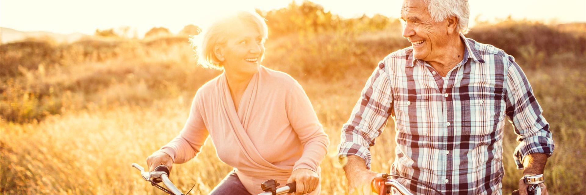 Ouder echtpaar fietsend door de natuur